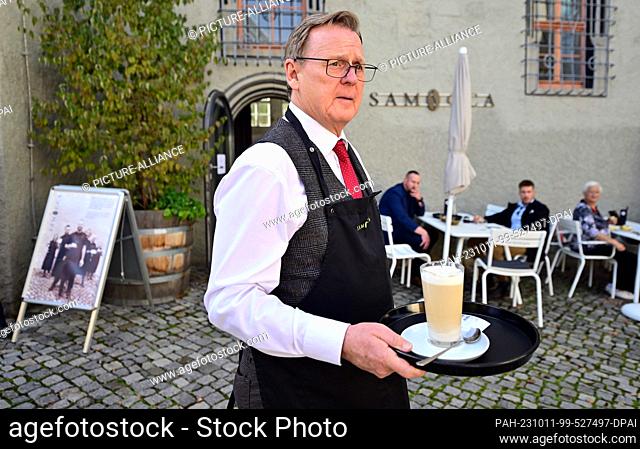 11 October 2023, Thuringia, Weimar: Bodo Ramelow (Die Linke), Prime Minister of Thuringia, serves coffee specialties at the Samocca Café Weimar