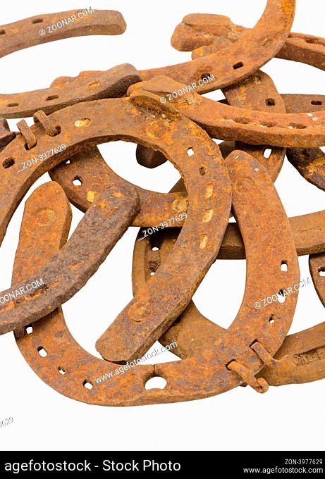 stack of old retro horse shoes isolated on white background