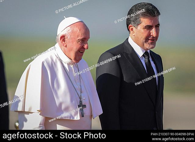 07 March 2021, Iraq, Erbil: Nechirvan Barzani (R), President of the Kurdistan Region, receives Pope Francis upon his arrival at Erbil International Airport...