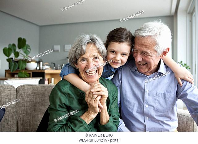 Family portrait of grandparents and their granddaughter at home