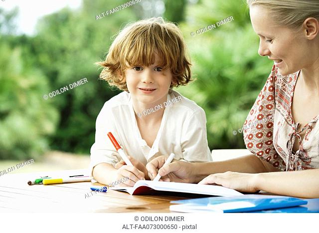 Boy coloring with his mother