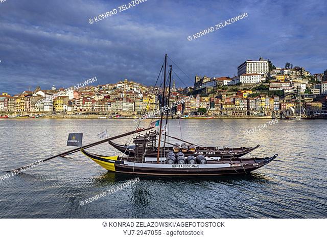 Cockburn's and Rozes Port wine boats called Rabelo Boats on a Douro River in Vila Nova de Gaia city. Porto city river bank on background