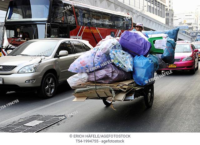 Garbage collector with a bicycle rickshaw in traffic of Bangkok