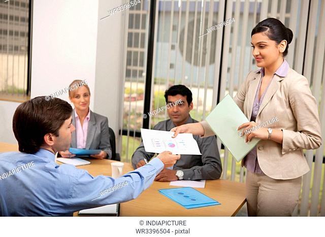 Female executive handing over a document