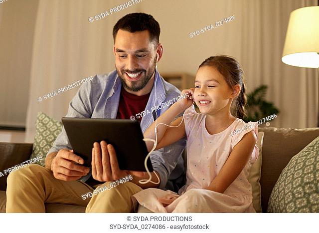 father and daughter listening to music on tablet