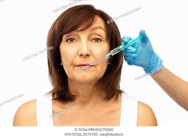 senior woman and surgeon hand with syringe