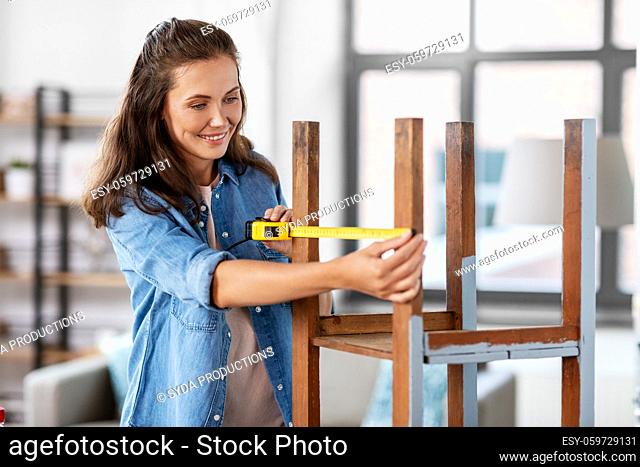 woman with ruler measuring table for renovation