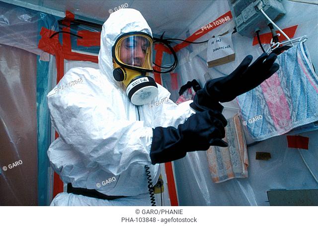 Worker putting on a protection suit before working on asbestos removal site