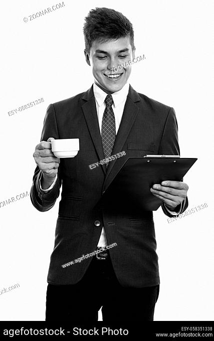 Studio shot of young handsome businessman in suit isolated against white background in black and white