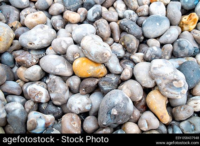 Close up of the pebbles on a beach in Normandy France, creating an Abstract smooth round pebbles sea texture background