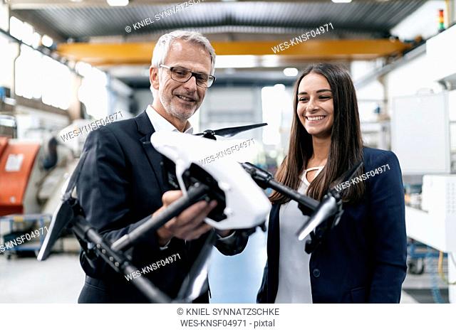 Businessman an woman in high tech enterprise, discussing production of drones