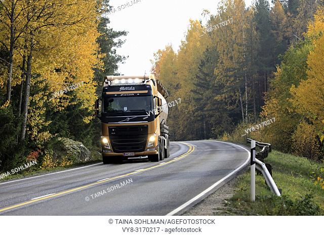 Salo, Finland - October 13, 2018: Volvo FH semi tanker of J. Mettala Ky for bulk transport delivers load on autumnal highway, high beams on briefly