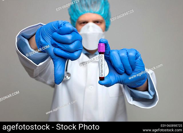 Health worker wearing a respiratory mask, holding the Coronavirus Covid-19 blood test sample