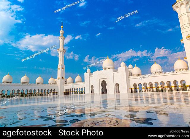 ABU DHABI, UAE - JUNE 11: The Sheikh Zayed Grand Mosque, muslims and tourists on June 11, 2013 in Abu Dhabi, UAE. It is the largest mosque in UAE and eighth...