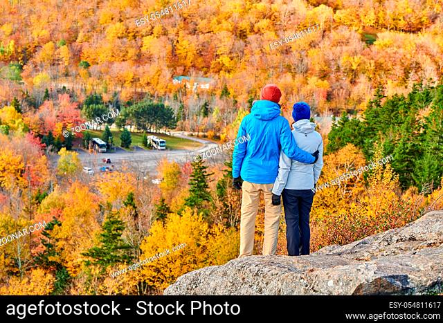Couple hiking at Artist's Bluff in autumn. Fall colours in Franconia Notch State Park. White Mountain National Forest, New Hampshire, USA