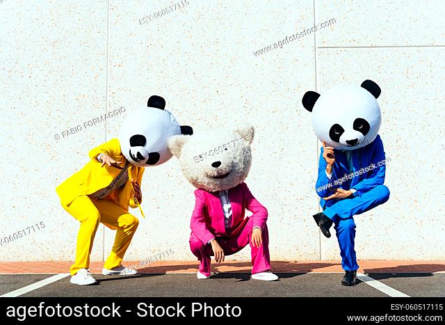 Storytelling image of a couple wearing giant panda head and colored suits. Man and woman making party in a parking lot