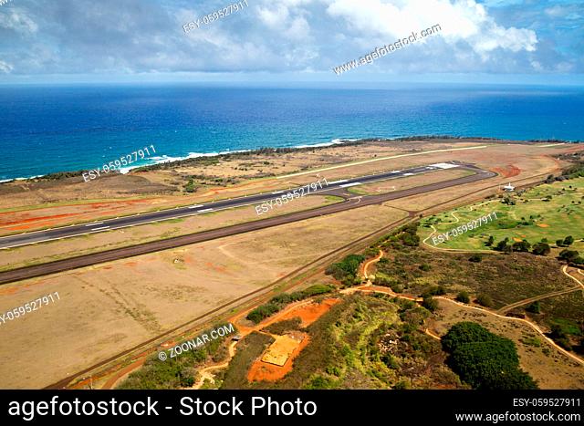 Luftaufnahme über dem Flughafen von Lihue, Kauai, Hawaii, USA mit Blick über die Landebahn auf die Küste. Aerial view towards the coastline over the airport of...