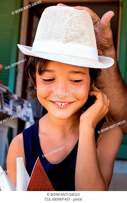Grandfather placing hat on boy's head