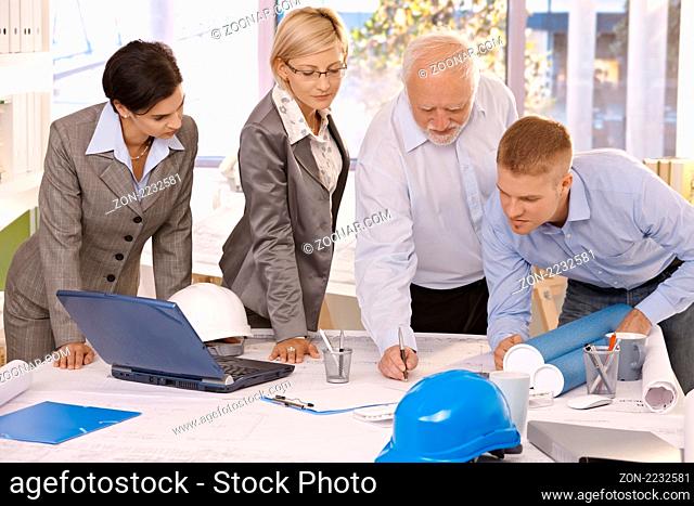 Architect team working together in office, senior designer drawing, coworkers watching