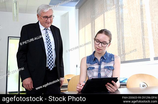 03 June 2020, Saxony-Anhalt, Barleben: Minister of Finance Michael Richter (CDU, l) gets information from seventh grader Lucy Herzog in a so-called iPad class...