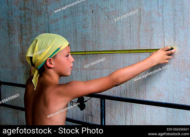teenager measuring a wall with roulette