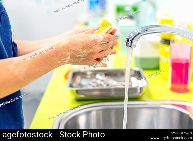 Coronavirus prevention. Close up unrecognizable nurse washing her hands after treat a patient with Covid-19 infection. Medical sanitizing procedure