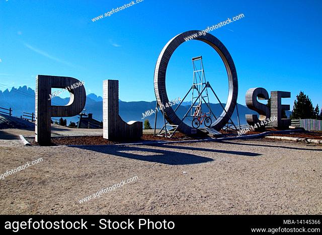 lettering plose, also called ploselooping, bicycle, deserted, in the morning, panoramic view from the plose to the geisler peaks in south tyrol, brixen, italy