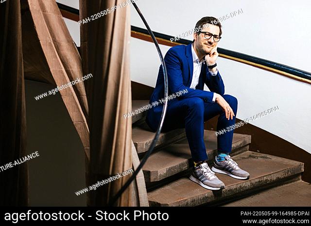 27 April 2022, Baden-Wuerttemberg, Freiburg: Martin Horn (independent), mayor of Freiburg, sits on the steps of a spiral staircase in the city's town hall