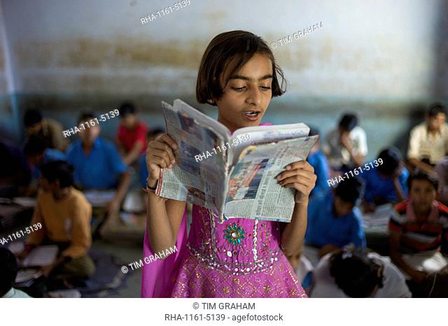 Indian girl reading aloud during English lesson at Rajyakaiya School in Narlai village, Rajasthan, Northern India