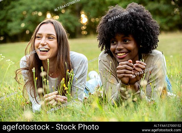 Smiling young female friends lying in park