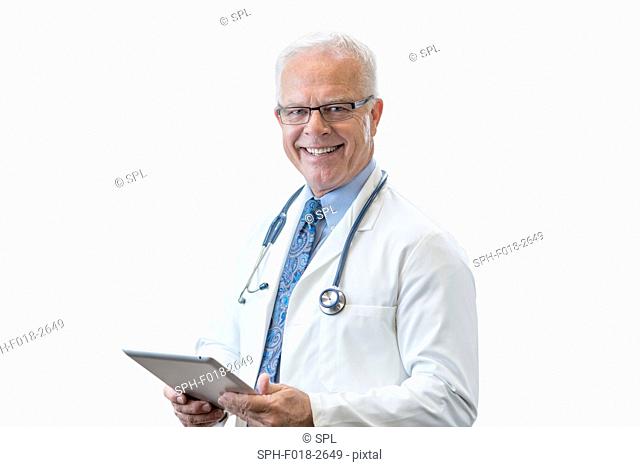 Senior male doctor with digital tablet, studio shot