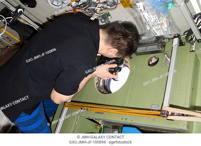 Russian cosmonaut Oleg Kononenko, Expedition 31 commander, uses a still camera at a window in the Zvezda Service Module of the International Space Station to...