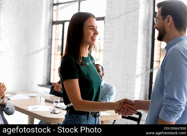 Boss welcoming corporate client people gathered in boardroom start business meeting. Employee got promoted, receive praises gratitude from head during briefing