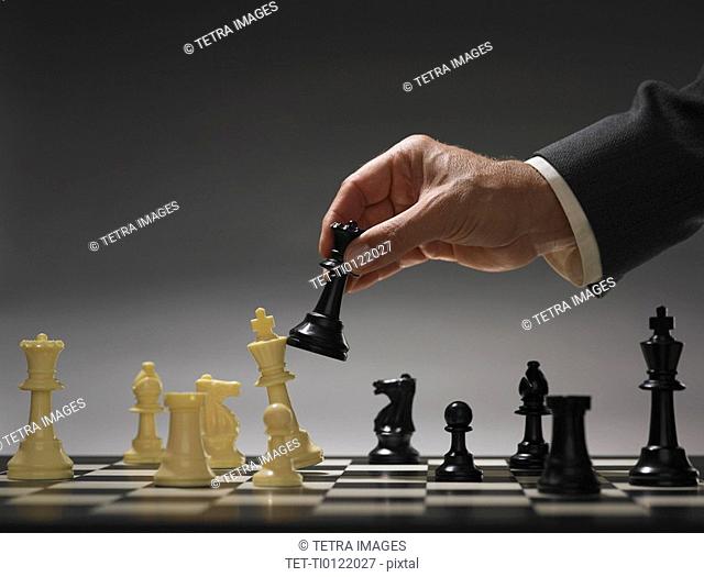 Businessman moving chess piece