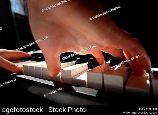 Details of Hands playing piano in room