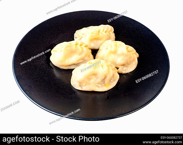 cooked Manti (type of dumpling in turkic cuisine) on black plate isolated on white background