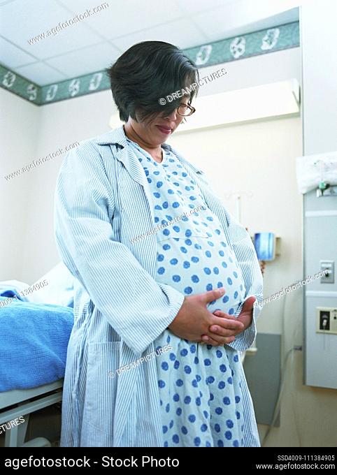 Pregnant Asian woman in hospital gown