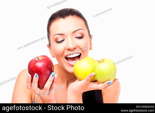 Beautiful happy young woman holding one red and two green apples. Isolated on white background. Copy space