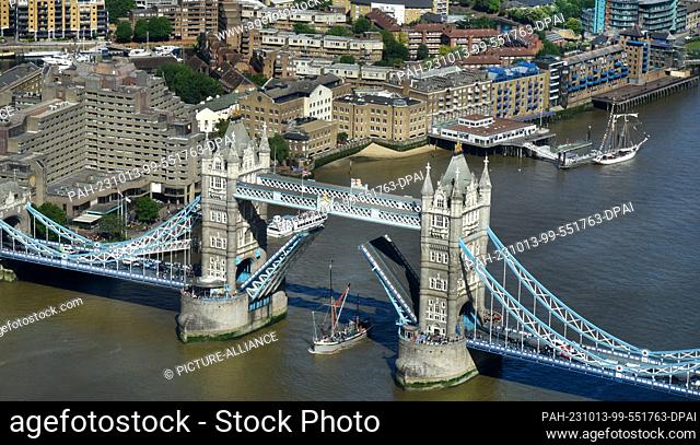 27 May 2022, Great Britain, London: A boat passes under the raised Tower Bridge. The bridge is raised about 900 times a year to allow ships to pass through