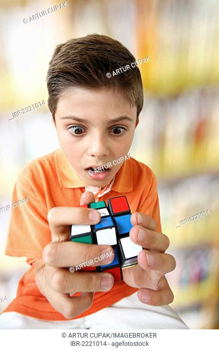 Confused looking boy with a magic cube