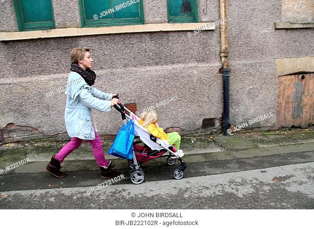 Mother out walking with toddler in buggy