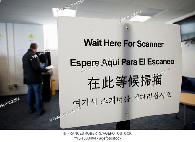 A sign instructs voters, in English Spanish, Chinese and Korean, to wait for the scanner, to cast their ballots in New York in Washington Heights on election...