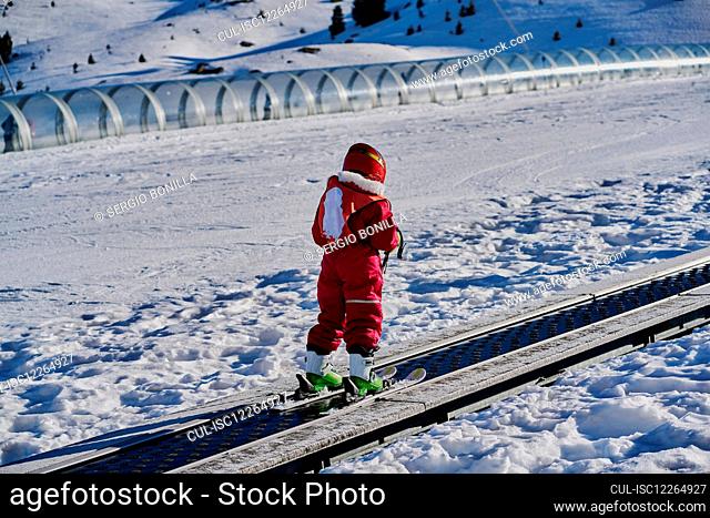Child on conveyor belt ski lift, Formigal ski resort, Spain