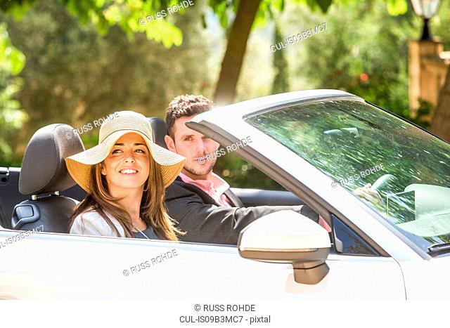 Happy couple driving convertible, Majorca, Spain