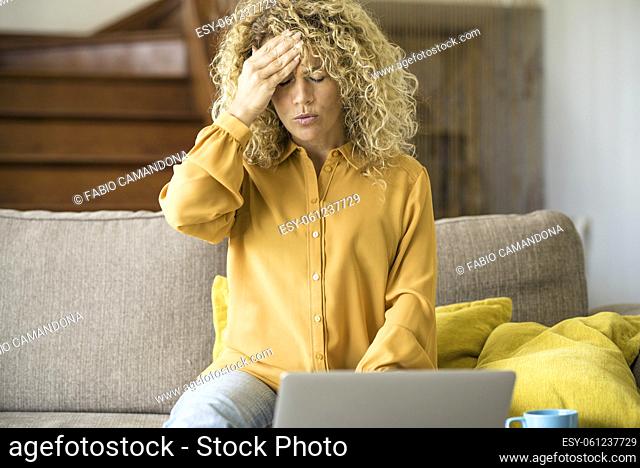 Overwork and stress bad health condition. Adult woman touching his front and head with pain. Tired and worried female people using laptop computer at home...