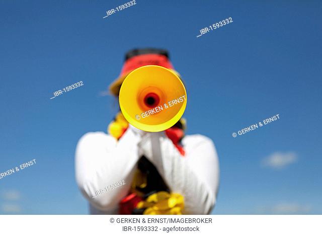 Young woman blowing in a Vuvuzela, black red gold, FIFA World Cup 2010