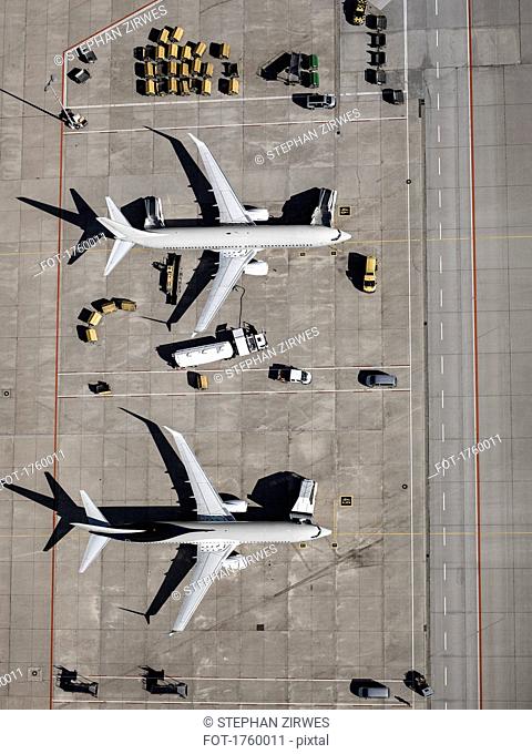 Aerial view commercial airplanes being serviced on tarmac at airport