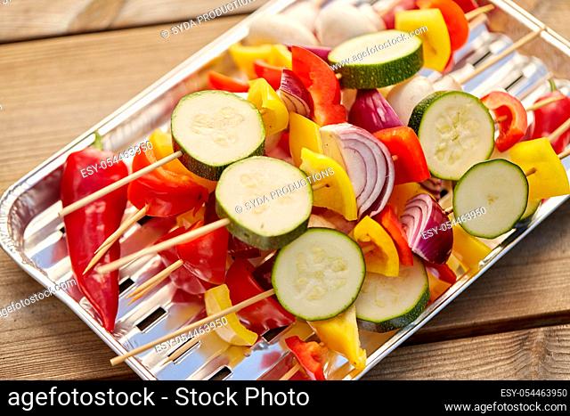 close up of vegetables on skewers on foil grill