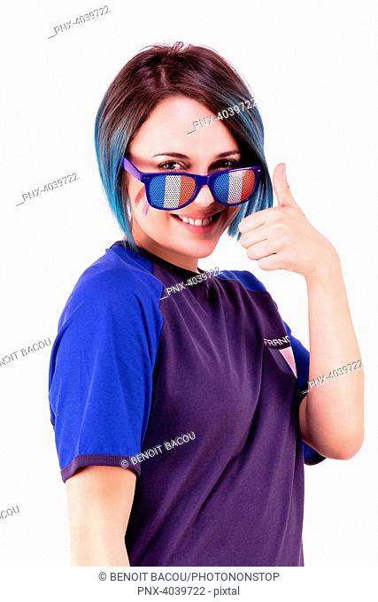 Portrait of a young supporter of the France football team wearing tricolor glasses