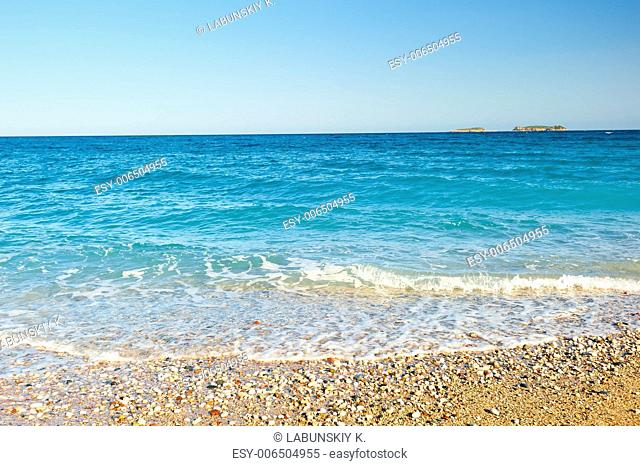 sea â€‹â€‹wave rolls on the sand and shingle beach at sunrise